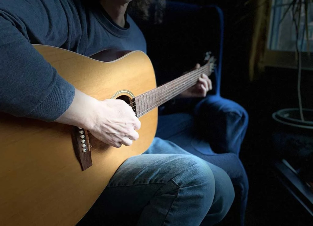 Shadowy photo of an acoustic guitarist