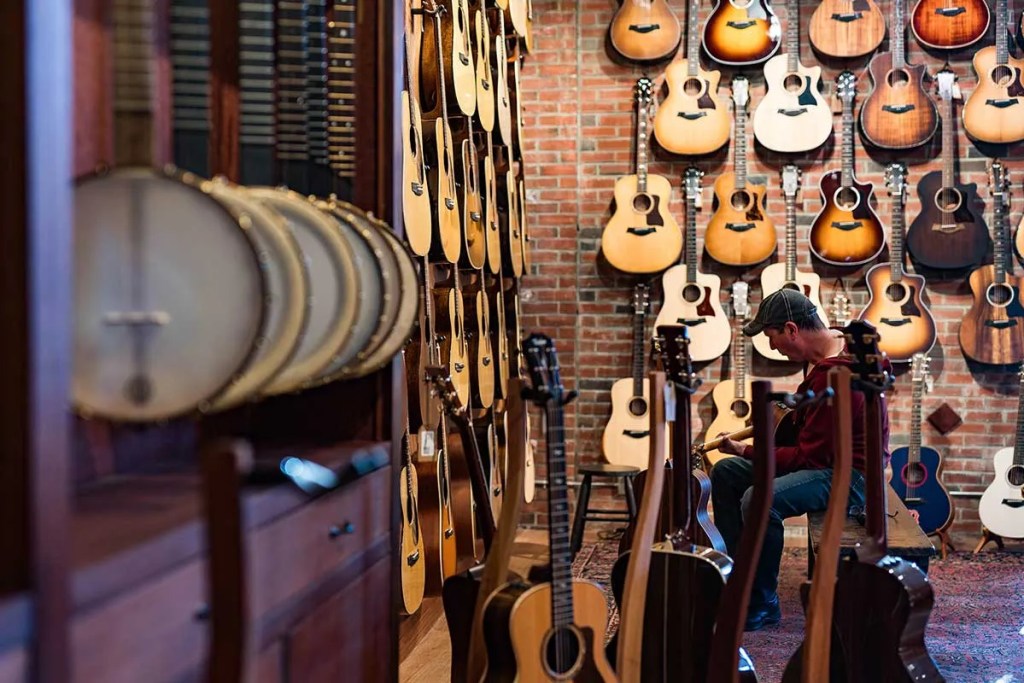 A customer plays an acoustic guitar at The Music Emporium, Photo: Andy Cambria/The Music Emporium